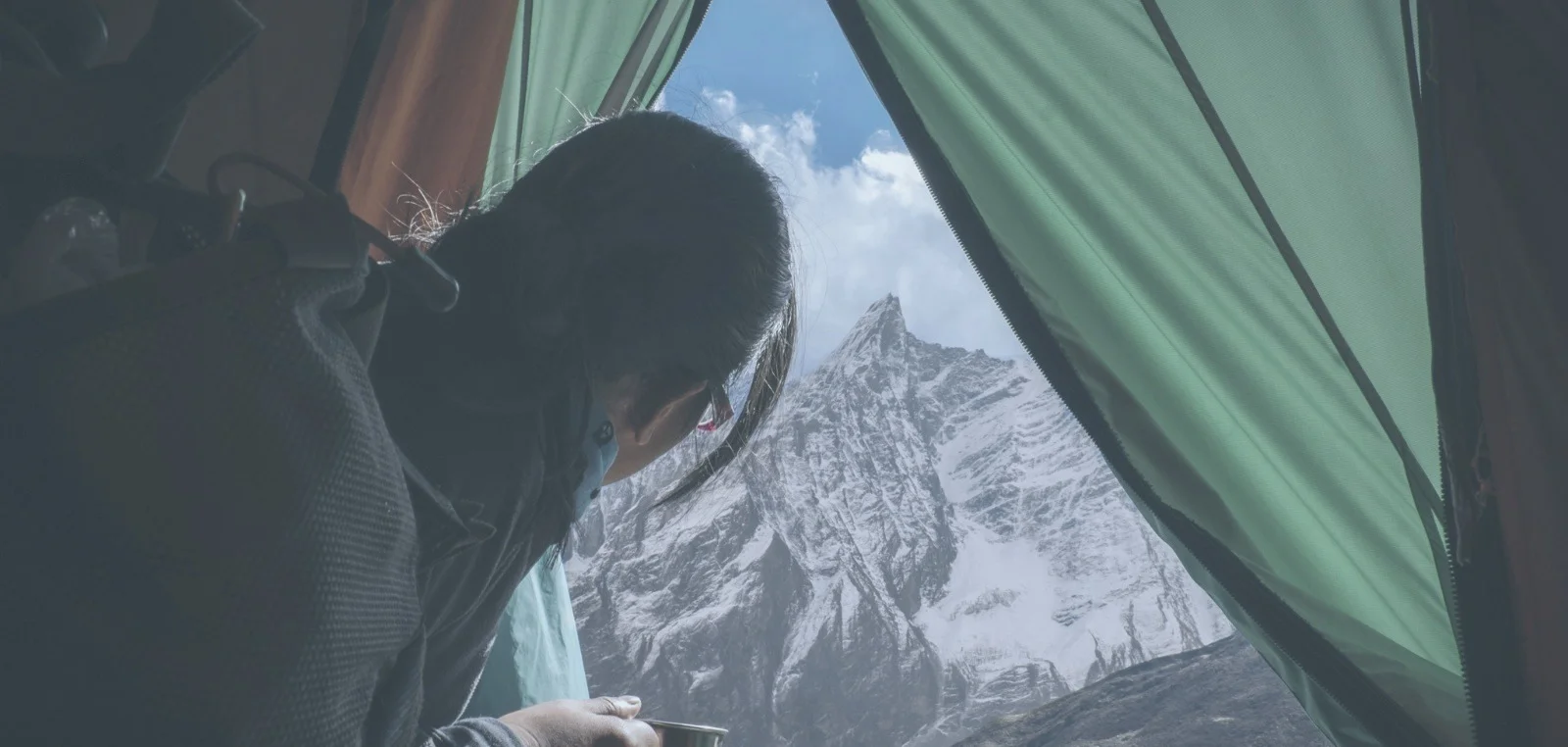 View of a snow-covered mountain peak from inside a tent